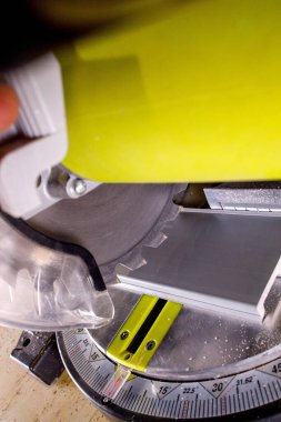 Kurulmadan önce dairesel testerenin süpürgeliğini kesen işçiler.