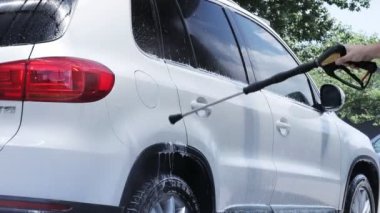 Araba yıkamada yüksek basınç altında arabayı köpük ve suyla yıkamak. Araba yıkama konsepti. Köpüklü araba..