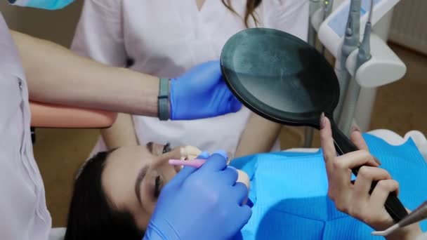Woman Sits Dentist Office Looks Mirror Dental Assistants Oral Hygiene — стоковое видео