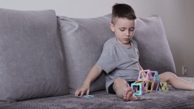 Manyetik inşaatçıyla oynayan küçük bir çocuk. Yaratıcılık gelişimi. Manyetik yapıcı.