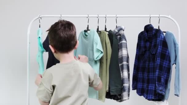 Bambino Età Prescolare Piedi Vicino Alle Grucce Racks Vestiti Sceglie — Video Stock