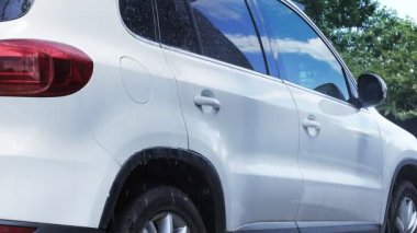 Araba yıkamada yüksek basınç altında arabayı köpük ve suyla yıkamak. Araba yıkama konsepti.