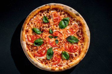 Delicious fragrant pizza with mozzarella, tomatoes and basil with tomato sauce - Margherita.