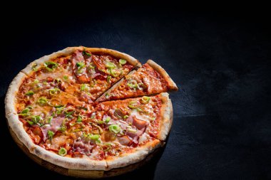 Delicious pizza with mozzarella cheese, ham, leeks on a tomato base.