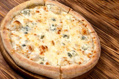 Dört peynirli pizza, mozzarella, mavi peynir, parmesan peyniri. İtalyan mutfağı. Ahşap bir arka planda. Yukarıdan görüntüle