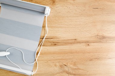 A sample of the finished fabric blind of the day and night system on a wooden background, copy space.