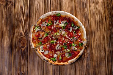 Vegan pizza with tomato sauce, cherry tomatoes, mushrooms, broccoli, red onion on wodenbackground. View from above.