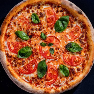 Delicious fragrant pizza with mozzarella, tomatoes and basil with tomato sauce - Margherita. Top view.