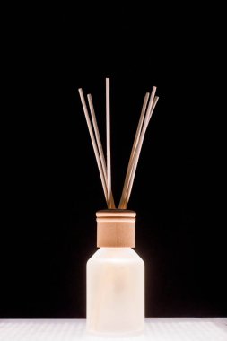 Fragrance for home. Aroma diffuser glass jar with aromatic liquid and bamboo sticks.