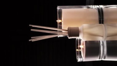 Air freshener in a glass bottle and scented candles in candle holders. Home atmosphere. Fragrances for the home. Vertical video