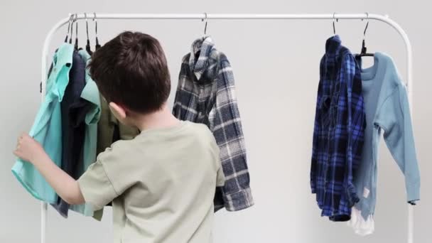 Мальчик Дошкольник Стоит Вешалок Собирает Одежду Выбирает Одежду Сегодня — стоковое видео
