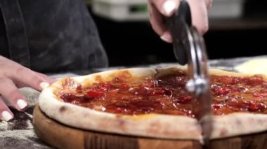 Freshly baked appetizing pizza, cut into slices with a pizza cutter. Pizza knife.