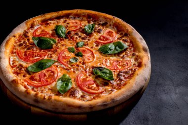 Delicious fragrant pizza with mozzarella, tomatoes and basil with tomato sauce - Margherita.