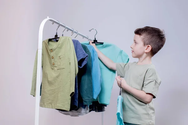 男孩子们站在衣架旁边 把衣服叠起来 为今天挑选衣服 — 图库照片