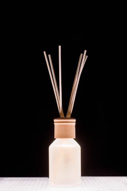 Fragrance for home. Aroma diffuser glass jar with aromatic liquid and bamboo sticks.