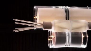 Air freshener in a glass bottle and scented candles in candle holders. Home atmosphere. Fragrances for the home. Vertical video.