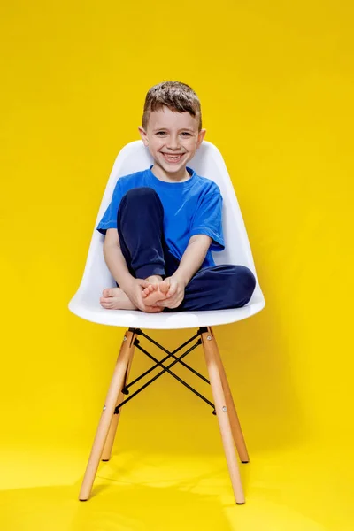 Niño Alegre Una Camiseta Casual Azul Pantalones Sentados Una Silla —  Fotos de Stock