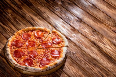 Domates soslu pizza, mozzarella, ahşap arka planda salam. Yukarıdan görüntüle, boşluğu kopyala.