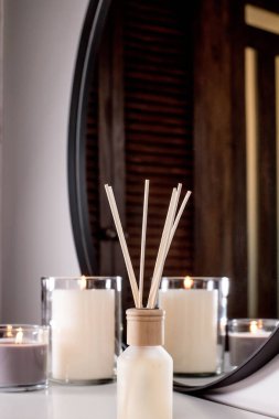 Aroma diffuser and scented candles that create coziness in the house. Romantic atmosphere. Details in the house that create coziness.