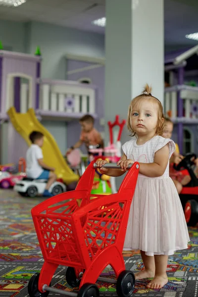 Cute Little Barefoot Girl Pink Dress Pushing Miniature Plastic Red — Fotografia de Stock