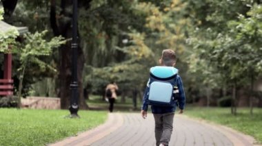 Sırt çantalı küçük çocuk okula gidiyor. Dikiz aynası. Birinci sınıf öğrencisi.