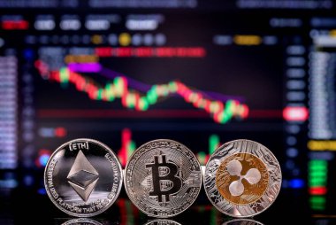 Para Bitcoin, ETH ve XRP arka plandaki kripto para ticareti şemasında bilgisayar ekranında. Dijital para, bankacılık, yatırım, finans ve iş konsepti.