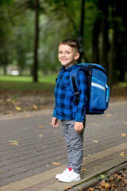 Sırt çantalı bir birinci sınıf çocuğunun portresi. Çocuk okula gidiyor..