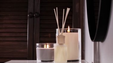 Aroma diffuser and scented candles that create coziness in the house. Romantic atmosphere. Details in the house that create coziness.