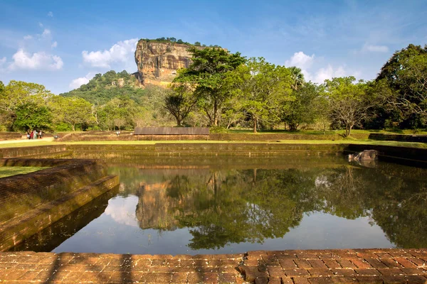 SIGIRIYA, SRI LANKA - 18 Şubat 2011: Sigiriya 'nın Büyük Kayası, Kraliyet Bahçeleri' ndeki küçük bir rezervuarın arkasında.