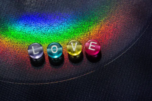 Das Wort Liebe Mit Perlenbuchstaben Als Liebeskonzept Auf Buntem Hintergrund — Stockfoto