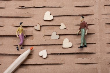 Küçük bir kadın ve erkek figürü. Minyatür model ve kalp aşk konsepti.