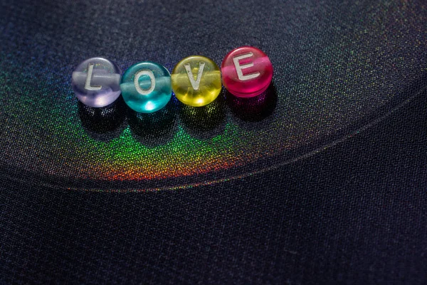 Das Wort Liebe Mit Perlenbuchstaben Als Liebeskonzept Auf Buntem Hintergrund — Stockfoto