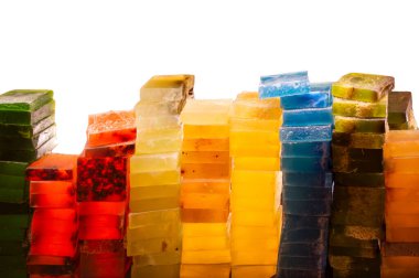 Beyaz üzerine izole edilmiş birçok ev yapımı sabun. El yapımı renkli sabun, vücut bakımı için spa banyo malzemeleri. Hijyen malzemeleri.