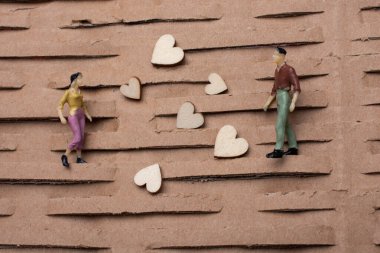 Küçük bir kadın ve erkek figürü. Minyatür model ve kalp aşk konsepti.