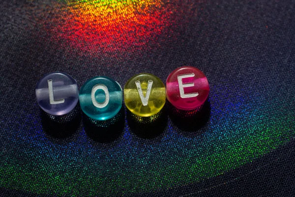 The word love with beads letters as love concept on  colorful background