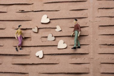 Küçük bir kadın ve erkek figürü. Minyatür model ve kalp aşk konsepti.