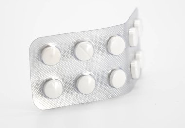 beyaz arka planda ambalaj kağıtlarında yuvarlak beyaz haplar, tıbbı, tableti kapat