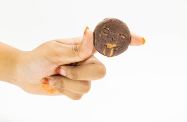 Beyaz arka planda izole edilmiş bir elde siyah bisküvi