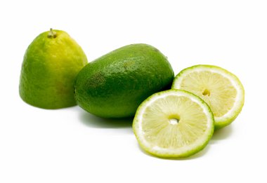 Taze ve taze dilimler yeşil limonlar beyaz arka planda izole edilmiş.
