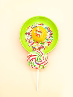 Renkli arka planda izole edilmiş şekerlemeli lolipop, üst görünüm