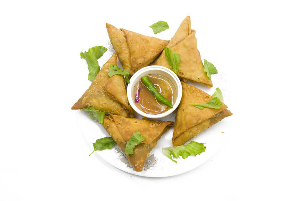 samosas и овощи изолированы на деревянном фоне