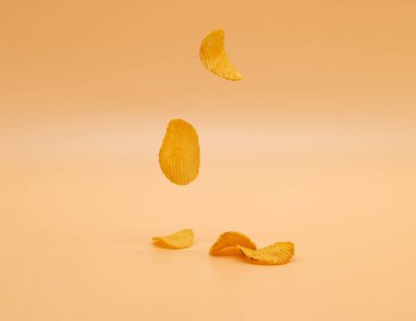Patates cipsleri renkli arkaplanda izole bir şekilde düşüyor, seçici odaklanma