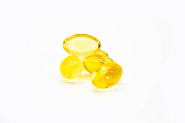 Omega 3 balık yağı kapsülleri olarak da bilinir. Beyaz arka planda izole edilmiş, seçici bir odak noktası vardır.