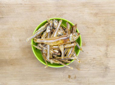 Kurutulmuş küçük balık ya da salamura ançüez balığı. Ahşap arka planda izole edilmiş.,