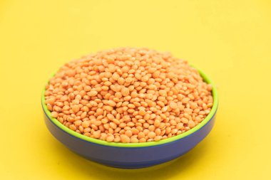 Kırmızı mercimek sarı arka planda izole edilmiş, ayrıca kuru turuncu mercimek taneleri olarak da bilinir, mazoor dhal.,