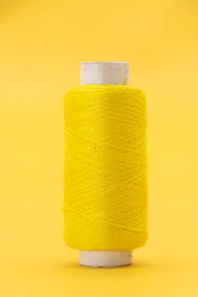 yellow color yarn or spool thread over on yellow background