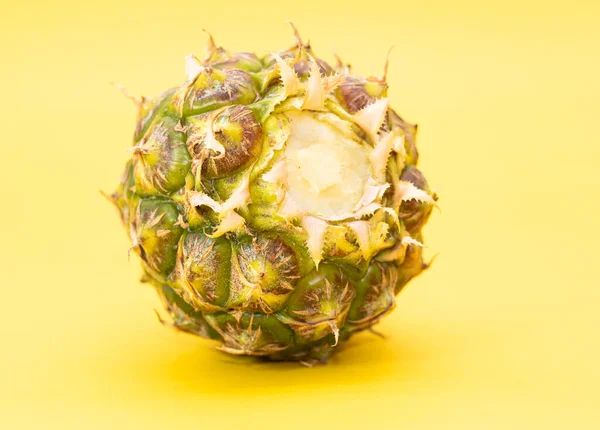 green pineapple isolated on yellow background, healthy rich fruit