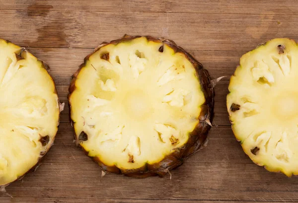 whole and slice pineapple with leaves isolated on wooden background, Flat lay