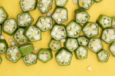 Sarı arkaplanda yalıtılmış bamya parçaları,