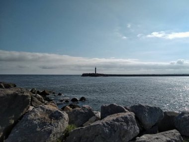Denizin arka planında deniz feneri olan güzel bir deniz manzarası..